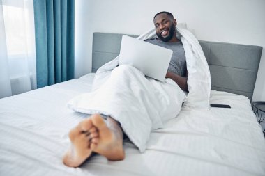 Kamerada poz veren koyu tenli erkek.