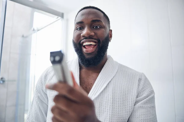 Joyful brunette man staring at his new gadget — ストック写真