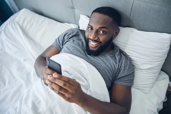 Yatağında yatan yakışıklı uluslararası adam.