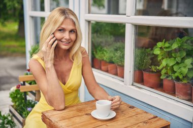 Masada oturan aletli bir kadın.