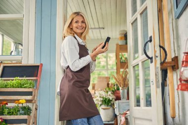 Gülümseyen kadın çalışan kameraya poz veriyor.