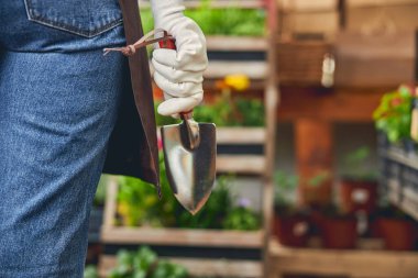 Elinde bahçe aleti olan bir kadın bahçıvan.