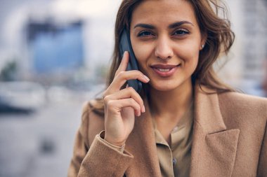 Genç bayan dışarıda bir telefon görüşmesi yapıyor.