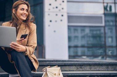 Aletleri olan neşeli, güzel bayan başka tarafa bakıyor.