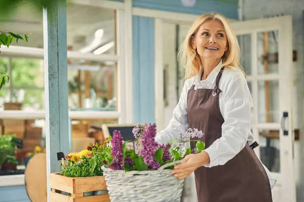 Lycklig kvinna florist håller en korg korg — Stockfoto