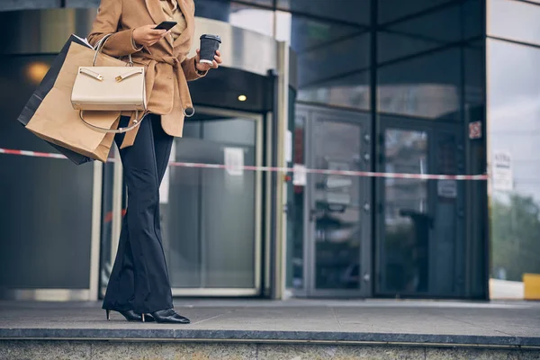 Vrouw in een stijlvolle jas met boodschappentassen — Stockfoto