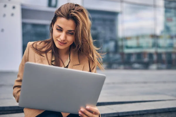 Femme agréable travaillant sur son ordinateur à l'extérieur — Photo