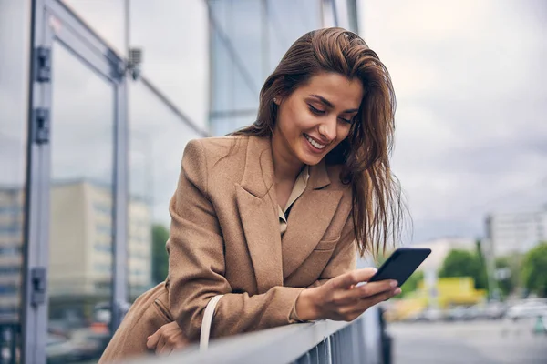 Έντονη γυναίκα της μόδας κοιτάζοντας το smartphone της — Φωτογραφία Αρχείου