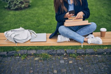 Öğrenci dışarıda tek başına çalışıyor.