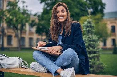 Çalışırken gülümseyen çekici esmer kadın.