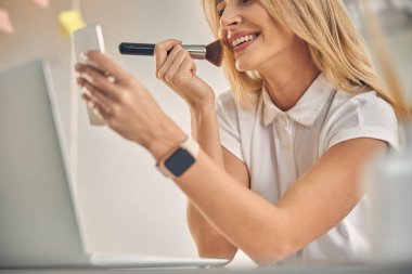 Ofiste makyaj yapan güzel bir genç kadın.