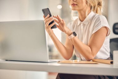 Ofiste cep telefonu kullanan zarif bir iş kadını.