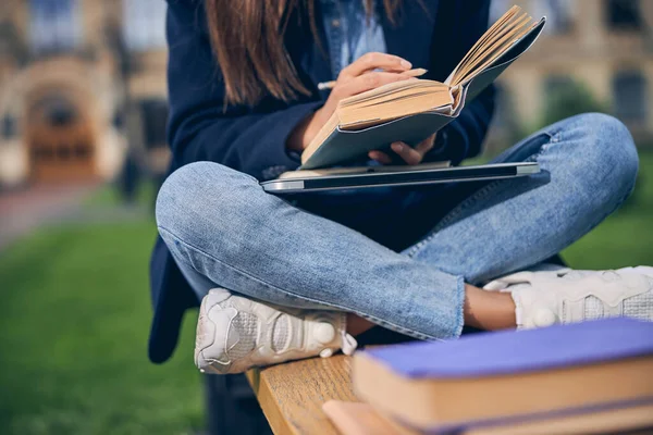 Dama en jeans usando lápiz para notas — Foto de Stock