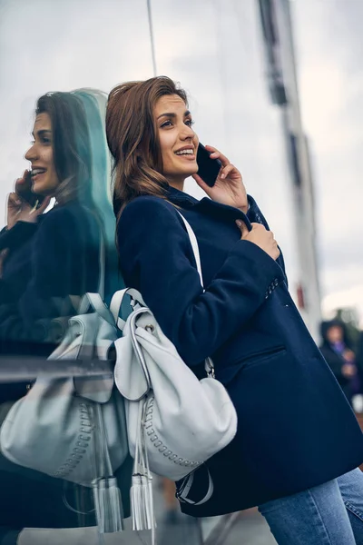 Cute female in casual clothes speaking on mobile