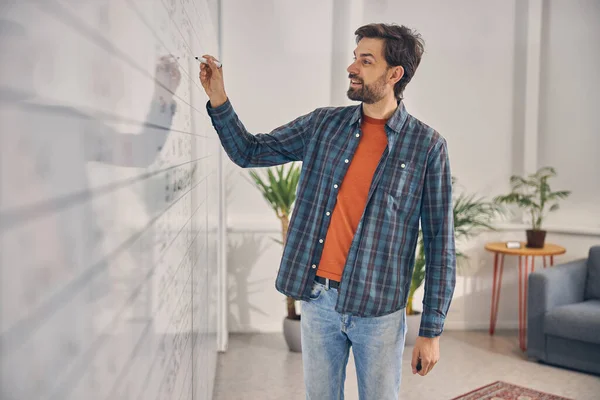 Fröhliche männliche Arbeiter schreiben auf Whiteboard im Büro — Stockfoto