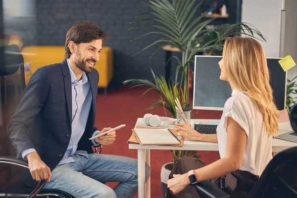 Compañeros de negocios alegres hablando en la oficina moderna —  Fotos de Stock