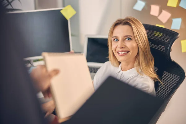 Giovane donna gioiosa che dà documenti al collega maschio — Foto Stock