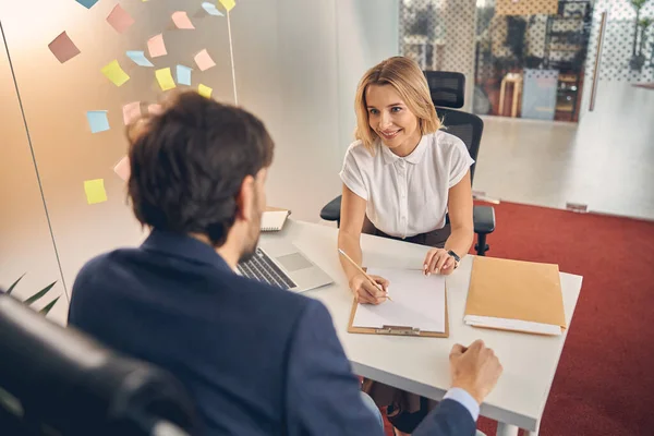 Charmante jonge vrouw die een ontmoeting met de klant in functie — Stockfoto