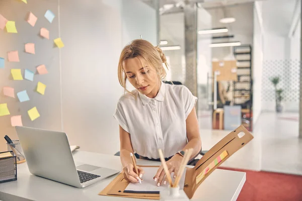 Mooie jonge vrouw werken met documenten in het kantoor — Stockfoto