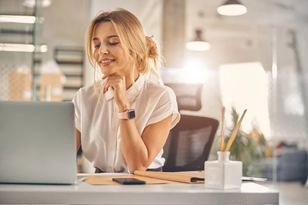 Attraente giovane donna che utilizza notebook moderno al lavoro — Foto Stock