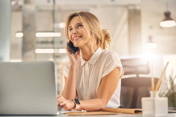 Joven alegre teniendo conversación telefónica en el trabajo —  Fotos de Stock