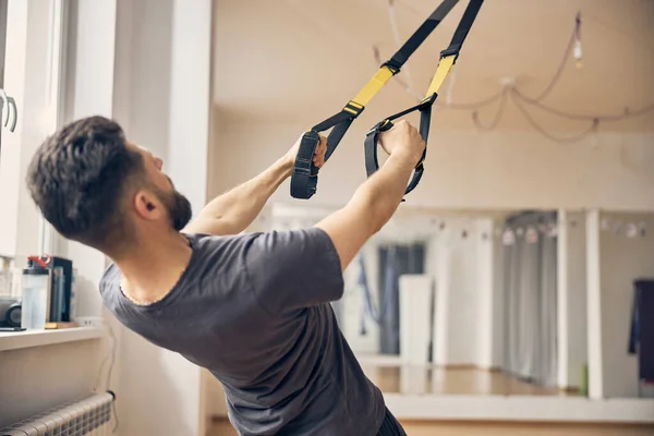 Deportista haciendo ejercicio con un entrenador de suspensión — Foto de Stock