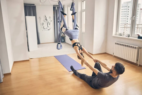 Slim female doing exercise in studio with instructor — Stock Photo, Image