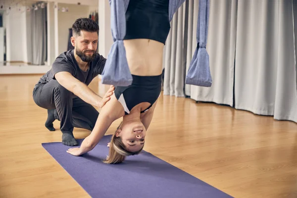 Joven mujer colgando en el aire mientras instructora experimentada le enseña —  Fotos de Stock