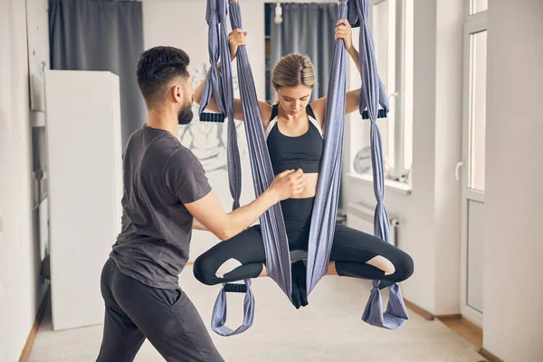 Woman doing aerial yoga in a fitness club — Stock Photo, Image