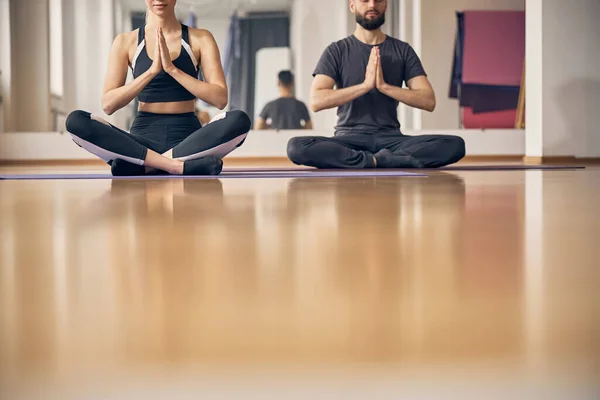 Homem e uma mulher meditando em uma pose de lótus — Fotografia de Stock