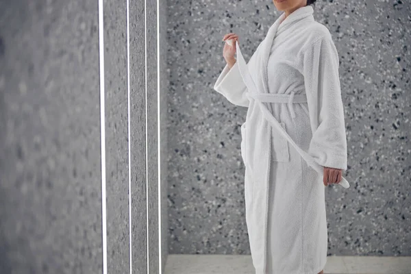 Woman in a bathrobe at the wall — Stock Photo, Image