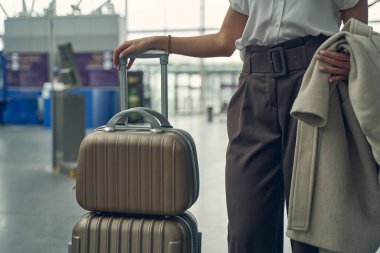 Şık bir genç kadın sabahını havaalanında geçiriyor.