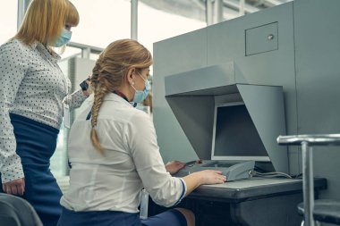 Röntgen makinesiyle çalışan iki güvenlik görevlisi.