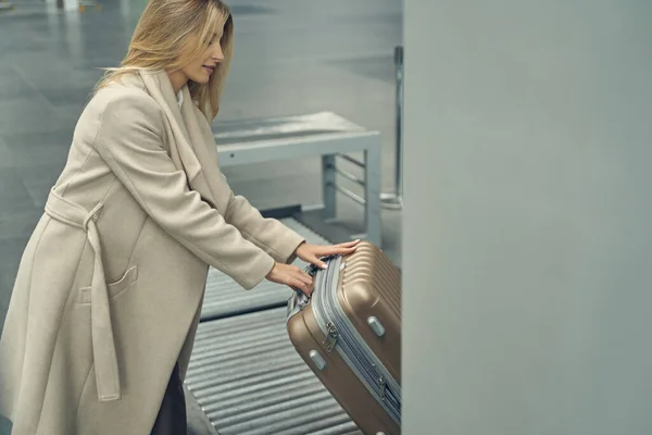 Junge Frau legt ihren Koffer auf den Boden — Stockfoto