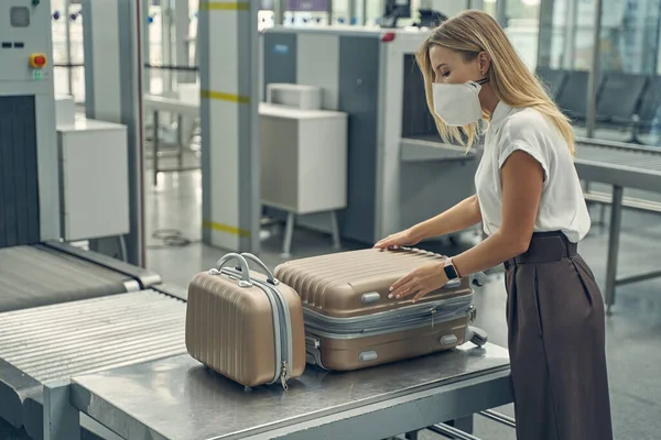 Figyelmes fiatal nő nyitja ki a bőröndjét — Stock Fotó