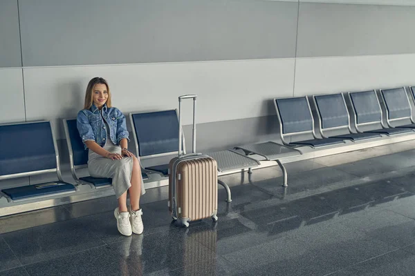 Positive delighted young lady waiting for the departure — Stock Photo, Image