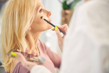 Rahat, uzun saçlı kadın yarı pozisyonunda oturuyor.