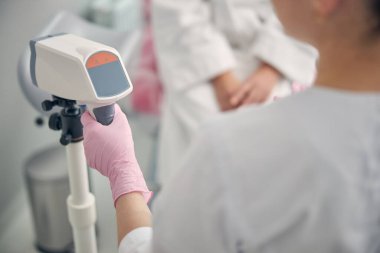 Kadın eline odaklanmış fotoğraf makinesini alıyor.