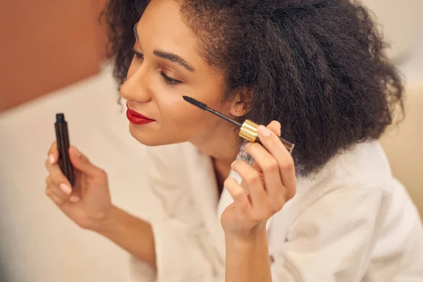 Jovem mulher afro-americana linda aplicando maquiagem — Fotografia de Stock