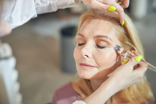 Foto focada na mulher idosa à espera de maquiagem — Fotografia de Stock