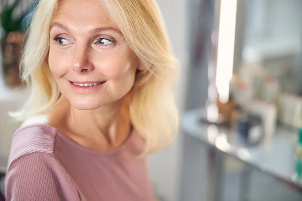 Retrato de una mujer guapa mirando a un lado por la ventana — Foto de Stock