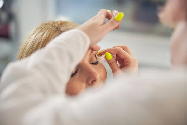 Close up de mãos femininas que fazem maquiagem — Fotografia de Stock