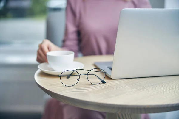 Occupato signora seduta in caffè con il suo computer portatile — Foto Stock