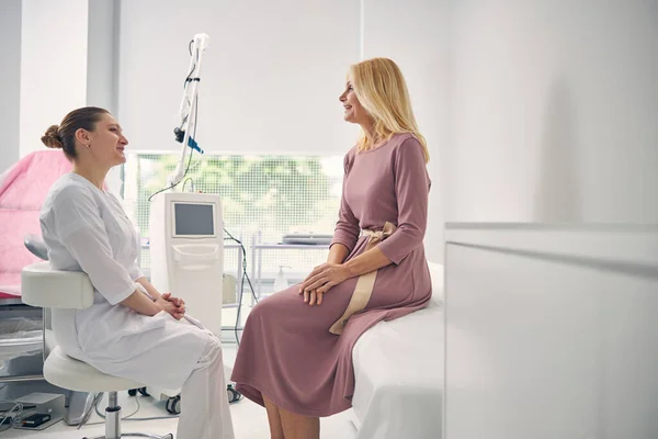 Wesoła blondynka rozmawia ze swoim lekarzem — Zdjęcie stockowe