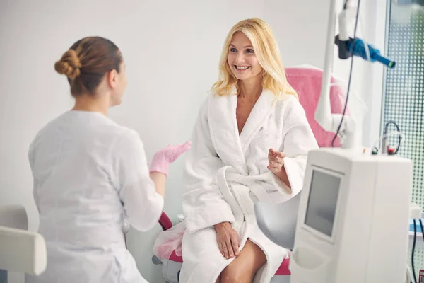 Attraente donna anziana ascoltando il suo medico — Foto Stock