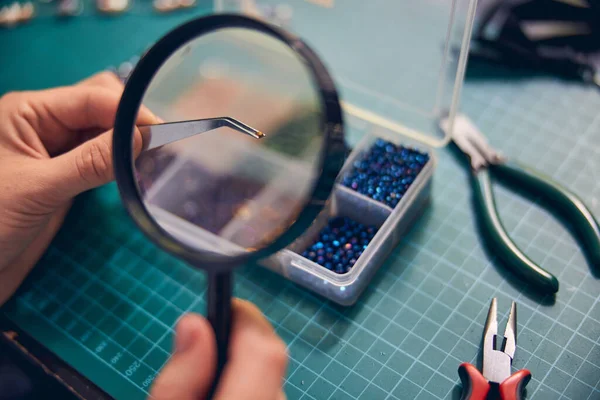 Manos del fabricante de joyas elemento de material de zoom con una lupa — Foto de Stock