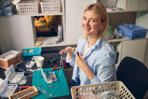 Mulher branca sorridente trabalhando no estúdio de bijouterie — Fotografia de Stock