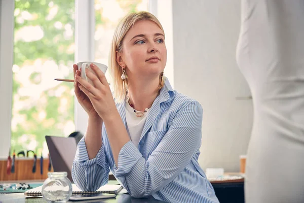 Femme vêtue occasionnellement pendant une pause paisible au bureau — Photo