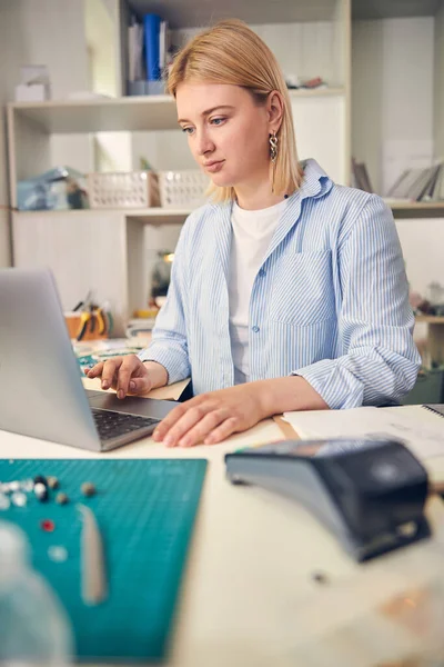 Mujer ocupada usando una computadora portátil en un taller de joyas —  Fotos de Stock