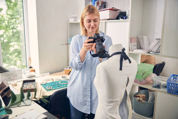 Mujer sonriente tomando una foto en un estudio de trabajo —  Fotos de Stock